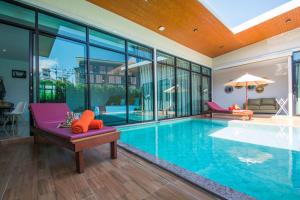 einen Pool mit einer lila Bank in einem Haus in der Unterkunft Good Night Pool Villa Phuket - SHA Plus in Phuket