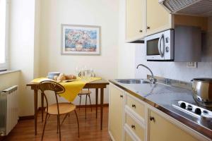 a kitchen with a small table and a yellow towel at Residence Liberty in Trieste