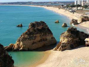 a beach with large rocks in the water at Estudio Centro de Alvor in Alvor