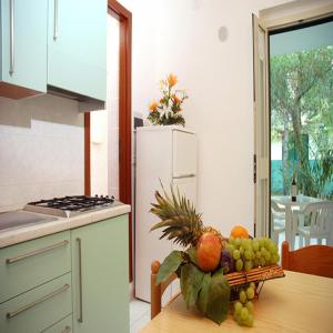 una cucina con tavolo e un mucchio di frutta di Villaggio Sabbiadoro a Vieste