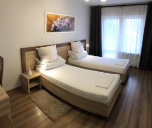 una camera d'albergo con due letti e una finestra di Hotel Restauracja Prezydencka a Legionowo