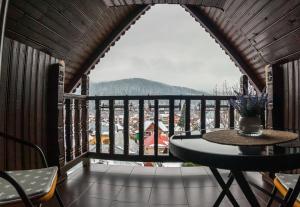 a balcony with a table and a view of a city at Casa Lazar in Buşteni