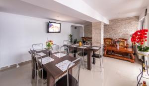 uma sala de jantar com mesas e cadeiras e uma parede de tijolos em Casa Lazar em Buşteni