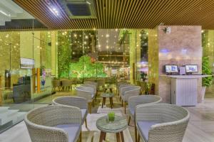 um restaurante com cadeiras e mesas e um bar em Poseidon Nha Trang em Nha Trang
