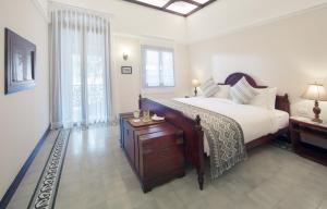 Un pat sau paturi într-o cameră la Le Bel Air Resort Luang Prabang