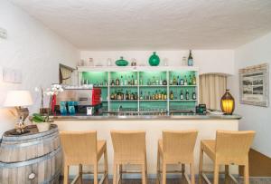 a kitchen with a table, chairs, and a refrigerator at Hotel 3 Botti in Baja Sardinia