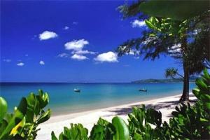 a beach with two boats in the water at Kata Plaza 1 bedroom Modern Apartment in Kata Beach