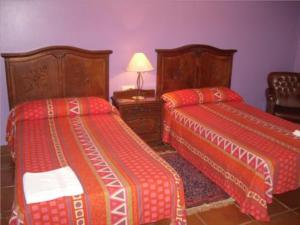 a bedroom with two beds and a table with a lamp at Agroturismo Orortegi in Aia