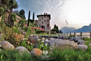 a house with a pond in front of a building at Villa Marina - Como lake in Bellano +95 photos