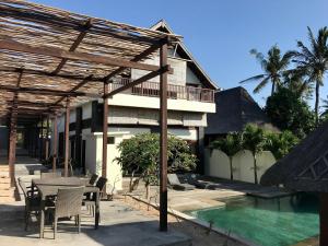 a patio with a table and chairs next to a building at Villa Bella Vista in Nusa Lembongan