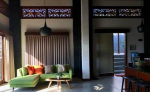 a living room with a green couch and a table at Villa Bella Vista in Nusa Lembongan