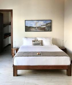 a bedroom with a large bed with a painting on the wall at Villa Bella Vista in Nusa Lembongan