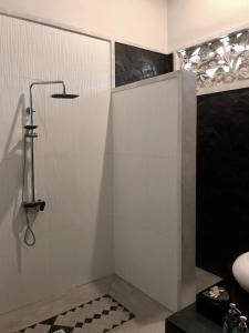 a shower stall in a bathroom with a black and white at Villa Bella Vista in Nusa Lembongan