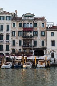 a group of boats in the water in front of buildings at Riva del Vin BOUTIQUE HOTEL in Venice