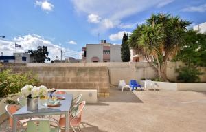 d'une terrasse avec une table, des chaises et des palmiers. dans l'établissement City Living Suite TK 1 Rm 1, à San Ġiljan