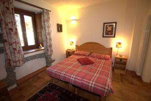 um quarto com uma cama com um cobertor xadrez e uma janela em La Grandze de François em Ollomont