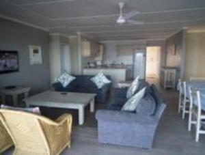 a living room with a couch and a table and chairs at Howela Beach House in Ballito
