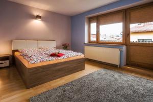 sypialnia z łóżkiem i dużym oknem w obiekcie Bastówka Apartamenty w Ustroniu