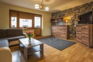 salon z kanapą i kamienną ścianą w obiekcie Bastówka Apartamenty w Ustroniu