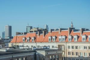 a building with a red roof in a city at APARTEL Plac Zbawiciela in Warsaw