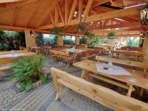 an outdoor restaurant with wooden tables and benches at Apartamenty Bahus - Centrum in Ustroń