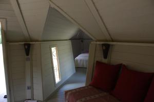 a small room with a bed and a window at Les Roulottes et Cabanes du Livradois in Cunlhat