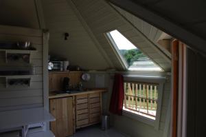 a kitchen in a tiny house with a window at Les Roulottes et Cabanes du Livradois in Cunlhat