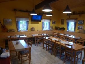 a dining room with wooden tables and chairs at Penzion Sněženka in Jiřetín pod Bukovou