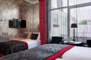 a hotel room with two beds and a window at The Pavilions Amsterdam, The Toren in Amsterdam