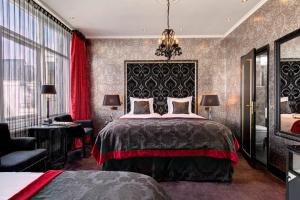 a bedroom with a large bed and a chandelier at The Pavilions Amsterdam, The Toren in Amsterdam