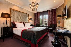 a hotel room with a bed and a desk and a window at The Pavilions Amsterdam, The Toren in Amsterdam