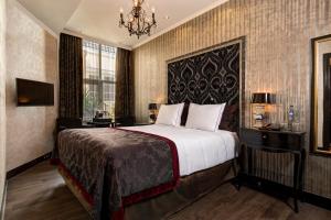a hotel room with a bed and a chandelier at The Pavilions Amsterdam, The Toren in Amsterdam