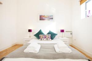 a white bedroom with a large bed with two lamps at Urban Living's - The Wren in Oxford