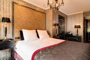 a bedroom with a large bed and a chandelier at The Pavilions Amsterdam, The Toren in Amsterdam