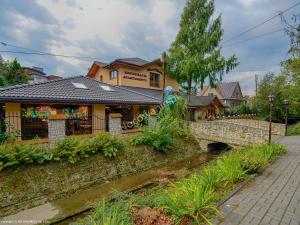 a house with a bridge next to a river at Apartamenty Bahus - Centrum in Ustroń