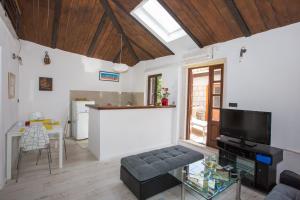 a living room with a tv and a kitchen at apartments kralj1 in Cavtat