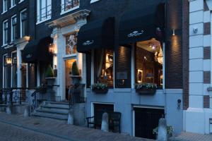 a store front of a building with black awnings at The Pavilions Amsterdam, The Toren in Amsterdam