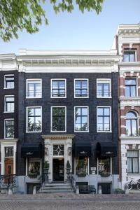 een groot zwart gebouw met ramen aan een straat bij The Pavilions Amsterdam, The Toren in Amsterdam