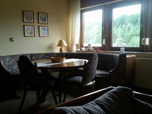 a dining room with a table and chairs and a window at Ferienhaus Raabe in Birresborn