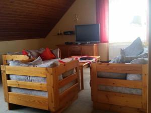 a living room with two beds and a tv at Ferienhaus Raabe in Birresborn
