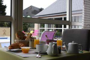 a table with breakfast food and orange juice and a window at L'Hippocampe in Plouharnel