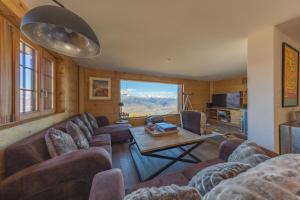 a living room with a couch and a table at Chalet Riquet - Ski/in-out - Jacuzzi in Nendaz