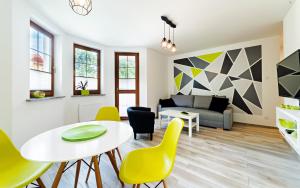 salon ze stołem, krzesłami i kanapą w obiekcie Apartamenty EverySky Nadrzeczna 3E-3D w mieście Karpacz