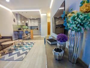 - un salon avec deux grands vases avec des fleurs dans l'établissement Verde Apartament, à Zielona Góra