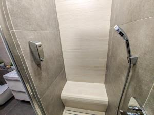 une douche avec un siège en bois dans une salle de bain dans l'établissement Verde Apartament, à Zielona Góra 14 autres photos