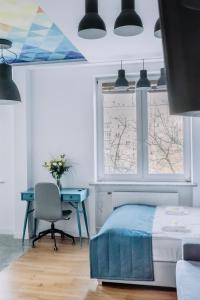 a bedroom with a bed and a desk and a window at APARTEL Plac Zbawiciela Studio in Warsaw