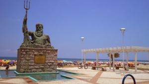 une statue d'une femme sur la plage dans l'établissement Praia Grande cond clube feirinha churras na sacada, à Praia Grande