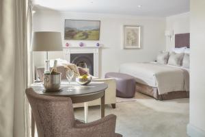 a living room with a bed and a table with a chair at The Samling Hotel in Windermere