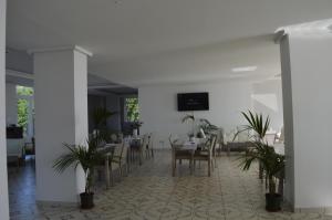 een eetkamer met een tafel en stoelen en planten bij Klaton Beach Hotel in Formia