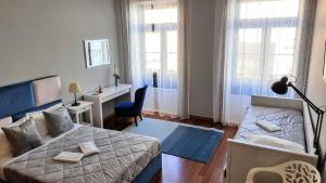 Un dormitorio con una cama, un escritorio y ventanas. en Cool Guesthouse, en Oporto